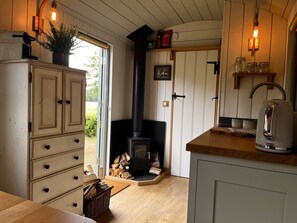 A cozy kitchen with a wood-burning stove, wooden cabinets, and a rustic aesthetic. - The Crooked Gate - Luxury Romantic Getaway (Maidstone)