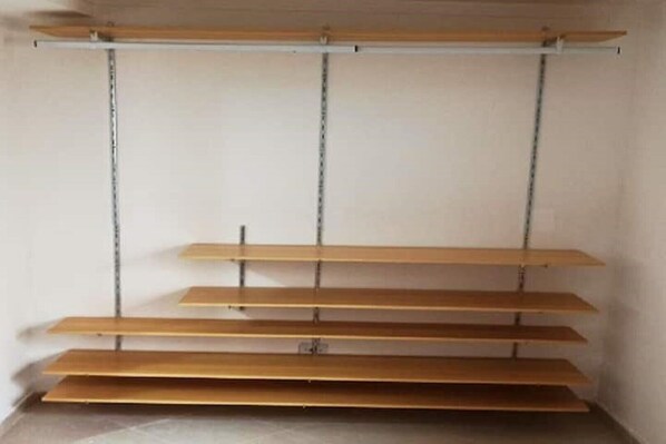 Una habitación con una estantería de madera adosada a la pared, sin objetos ni adornos a la vista.