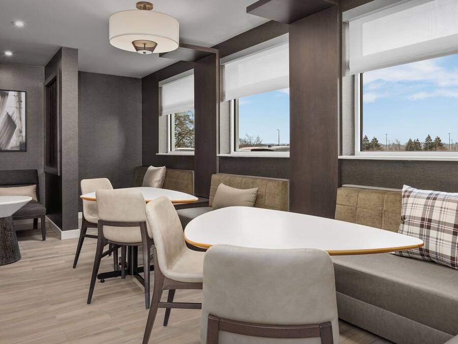 A modern interior with a dining area, seating, and large windows.