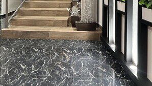 A modern interior with a staircase, marble flooring, a world map wall, and vertical garden panels. - Basha Hotel & Restaurant (San Pedro Sula)