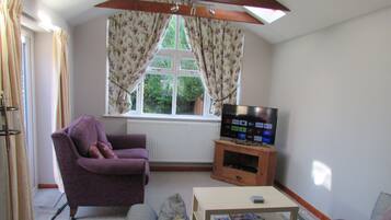 Relax in this cozy space with a comfortable armchair, flat-screen TV, and convenient table.