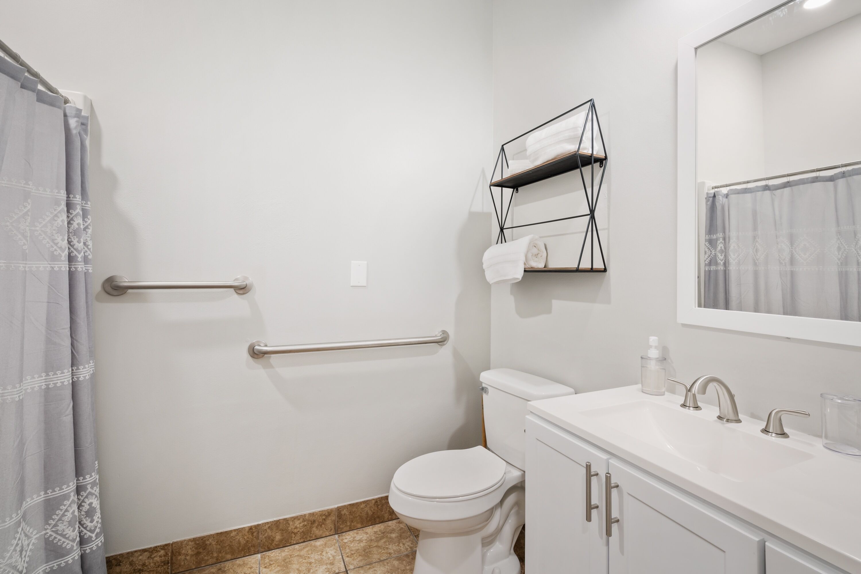Une salle de bain équipée de toilettes, d’un lavabo et d’un porte-serviettes.