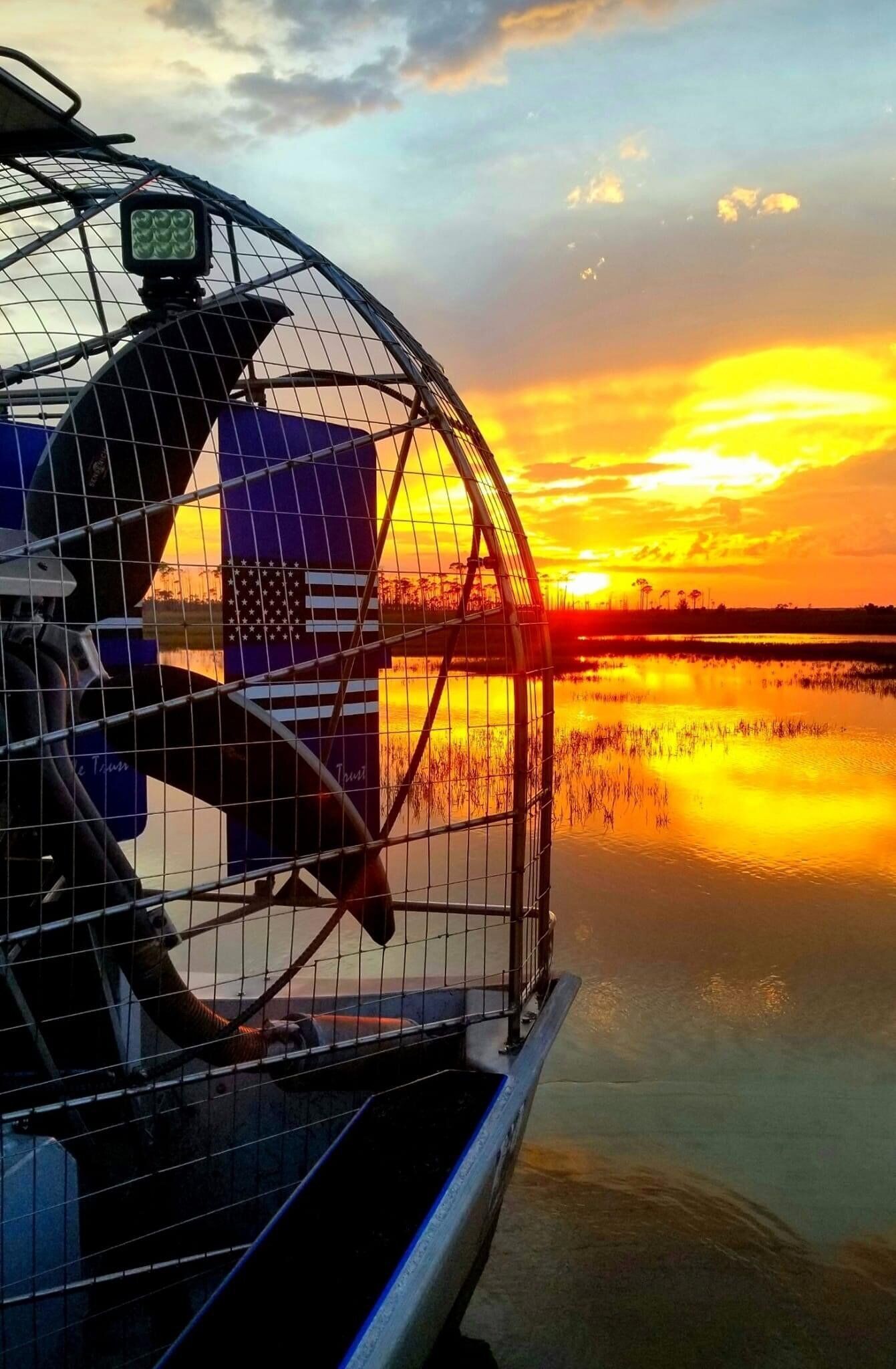 Ein Vogelkäfig mit Blick auf einen Sonnenuntergang über dem Wasser.