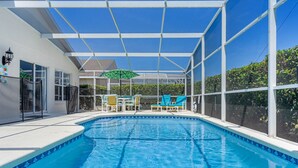 A swimming pool with a covered area, lounge chairs, and a pergola. - Spacious House, Near Disney, 4BDR & 3bath Sleeps up to 10,Game Room+ Heated Pool (Davenport)
