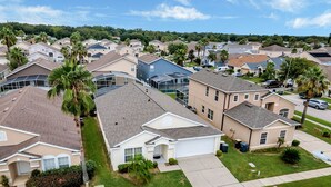 A residential neighborhood with single-family homes, well-maintained lawns, and a clear sky. - Spacious House, Near Disney, 4BDR & 3bath Sleeps up to 10,Game Room+ Heated Pool (Davenport)