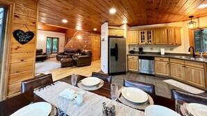 Un intérieur de chalet chaleureux comprenant un coin repas, une cuisine et un espace de vie.