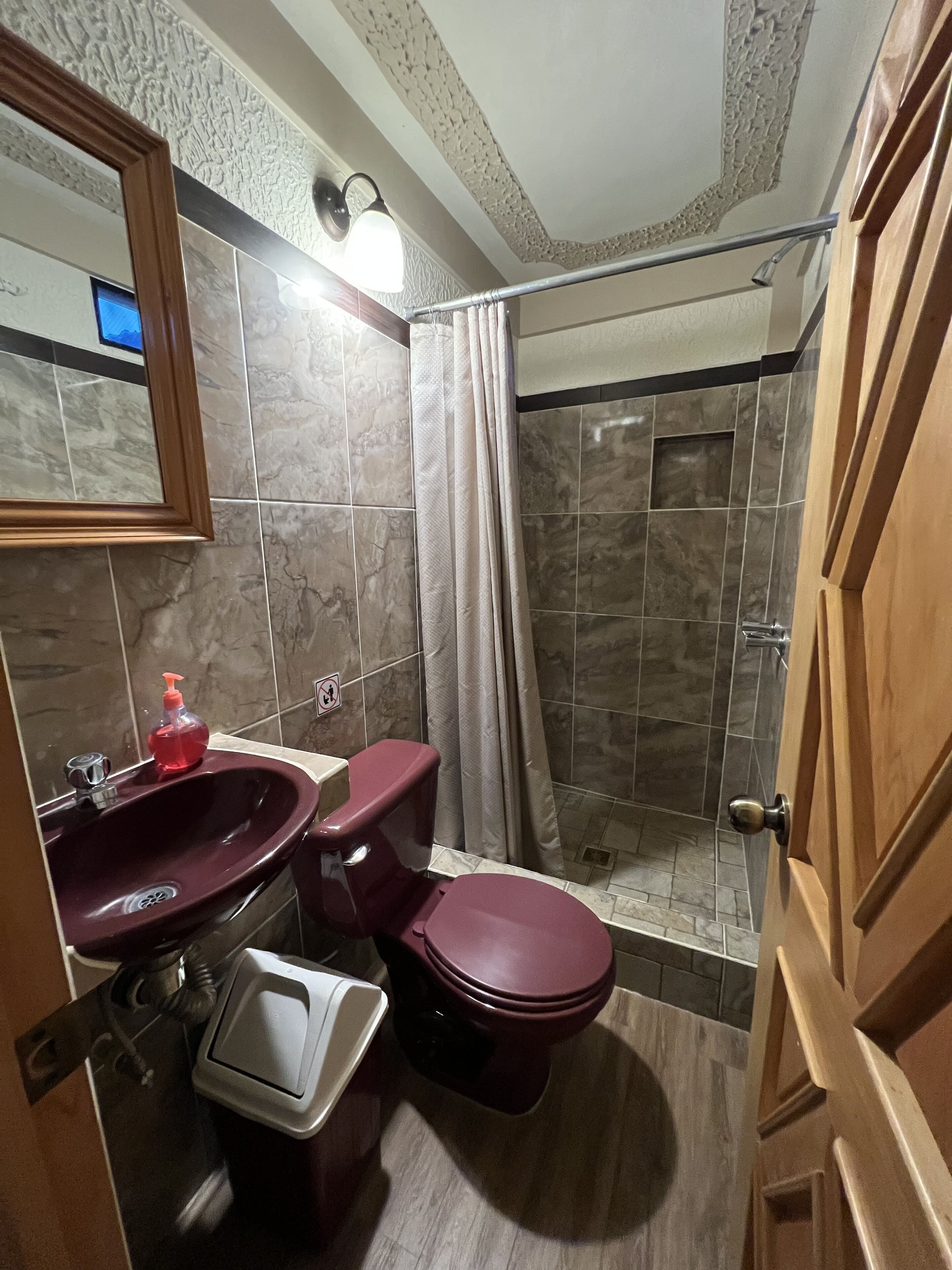 A bathroom with a marble sink, a toilet, and a shower.