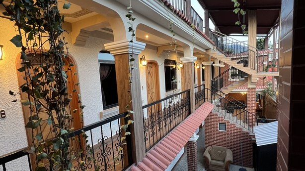 A multi-level outdoor patio with brick flooring, a wooden bench, and a staircase. - Hotel Posada don Miguel (Panajachel)