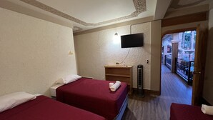 A hotel room with two beds, a TV, and a small desk. - Hotel Posada don Miguel (Panajachel)