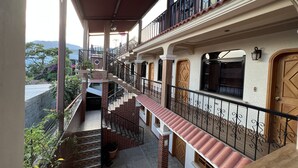 A multi-level residential building with a balcony, stairs, and a view of the surrounding landscape. - Hotel Posada don Miguel (Panajachel)