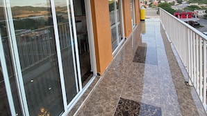 A hotel with a balcony, large windows, and a view of a mountain range. - July Apartments (Philipsburg)