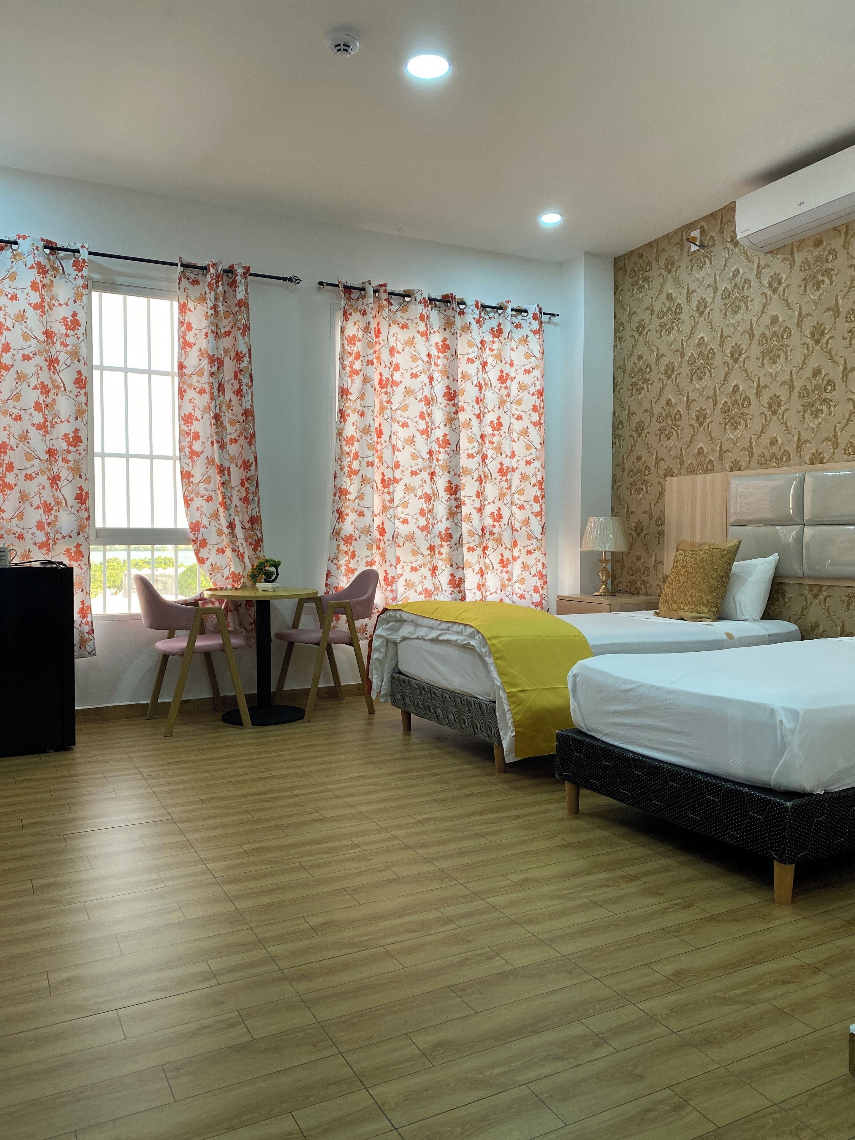 Habitación de hotel con dos camas, un escritorio y una silla.