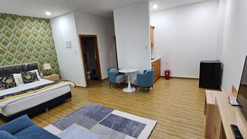 Una habitación de hotel moderna con cama, escritorio, silla y una pequeña mesa.