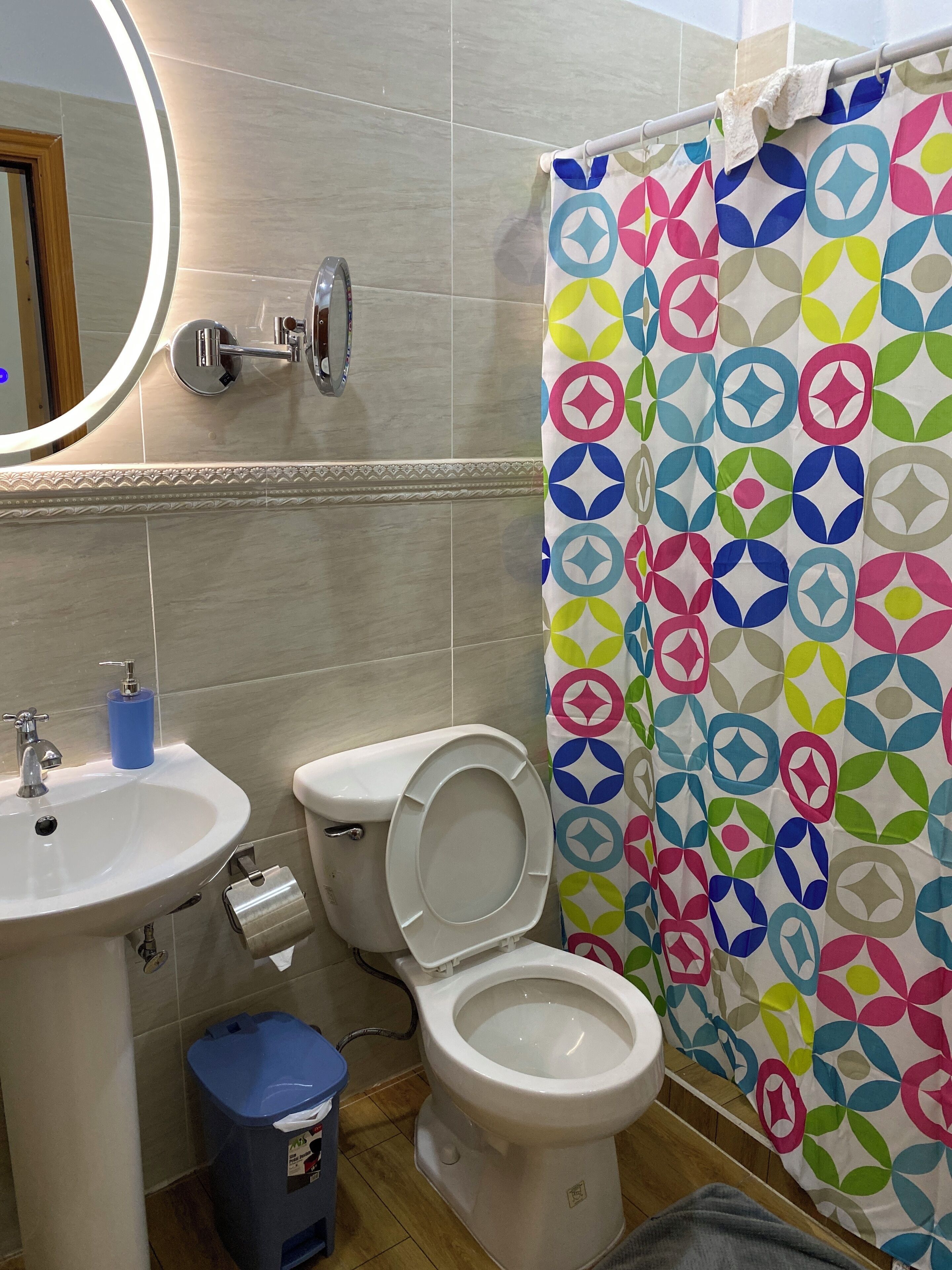 Un baño con inodoro, lavamanos y cortina de ducha.