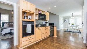 A modern kitchen with wooden cabinets, a built-in oven, and a microwave. - Location, Location, Location (Lexington)