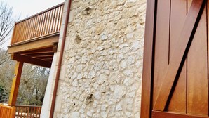 A stone exterior wall with a wooden balcony and a large wooden door. - Charming accommodation, next to Ribera del Duero and Hoces del Duratón (aldeasoña)