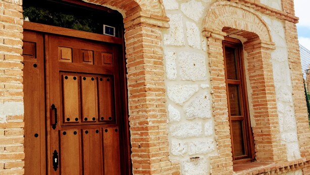 A building with a large wooden door and arched windows. - Charming accommodation, next to Ribera del Duero and Hoces del Duratón (aldeasoña)