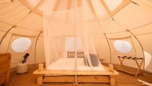 A tent with a bed, a small table, and a drying rack. - Paradise Ranch Inn - Mindful Tent (Three Rivers)