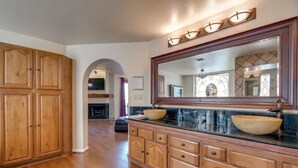 Una cocina amplia con armarios de madera, un espejo grande y una isla central con pileta.