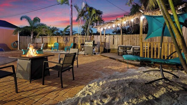 A backyard with a fire pit, outdoor furniture, and a grill.