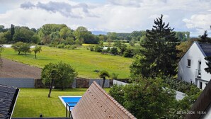 Zona residencial con piscina, césped verde y vista al río y árboles.