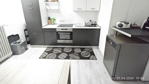 Una cocina compacta con horno integrado, un lavabo y una cafetera.