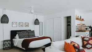 A modern bedroom with a bed, a white sofa, and a dining area with a microwave. - University District Guesthouse-Minutes to Nob Hill (Albuquerque)