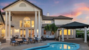 A large house with a pool, outdoor seating, and a covered patio.