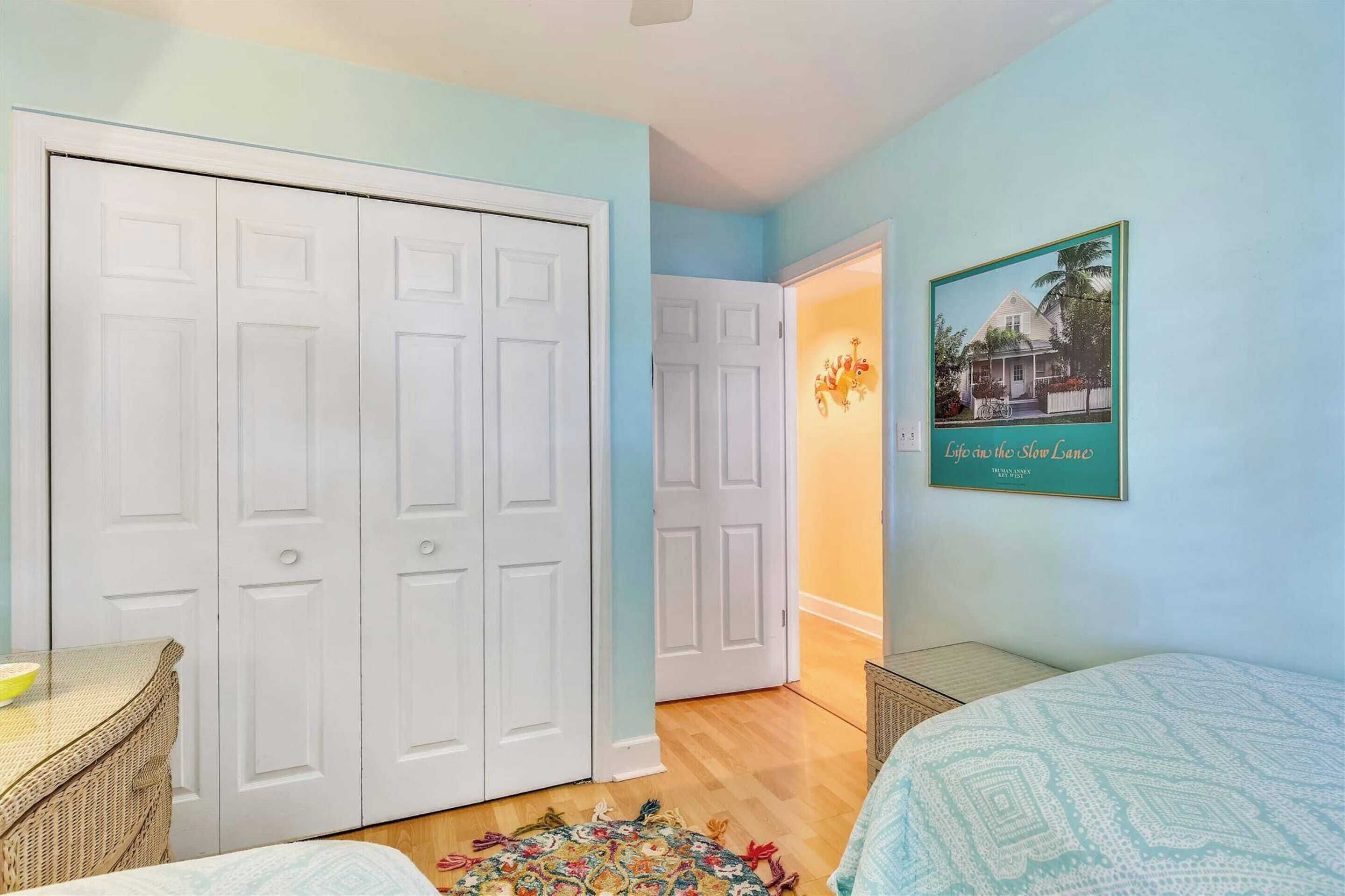 A bedroom with a bed, a dresser, and a wardrobe.