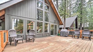 A wooden deck with Adirondack chairs, large windows, and a covered area with a grill. - 2 Mi to Tahoe Donner Ski Resort: Forest-View Haven (Truckee)