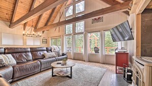 A spacious living room with a leather sofa, a round coffee table, and a fireplace. - 2 Mi to Tahoe Donner Ski Resort: Forest-View Haven (Truckee)