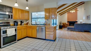 A modern kitchen with wooden cabinets, stainless steel appliances, and pendant lighting. - Fort Myers Home, Lanai & Private, Heated Pool (Fort Myers)