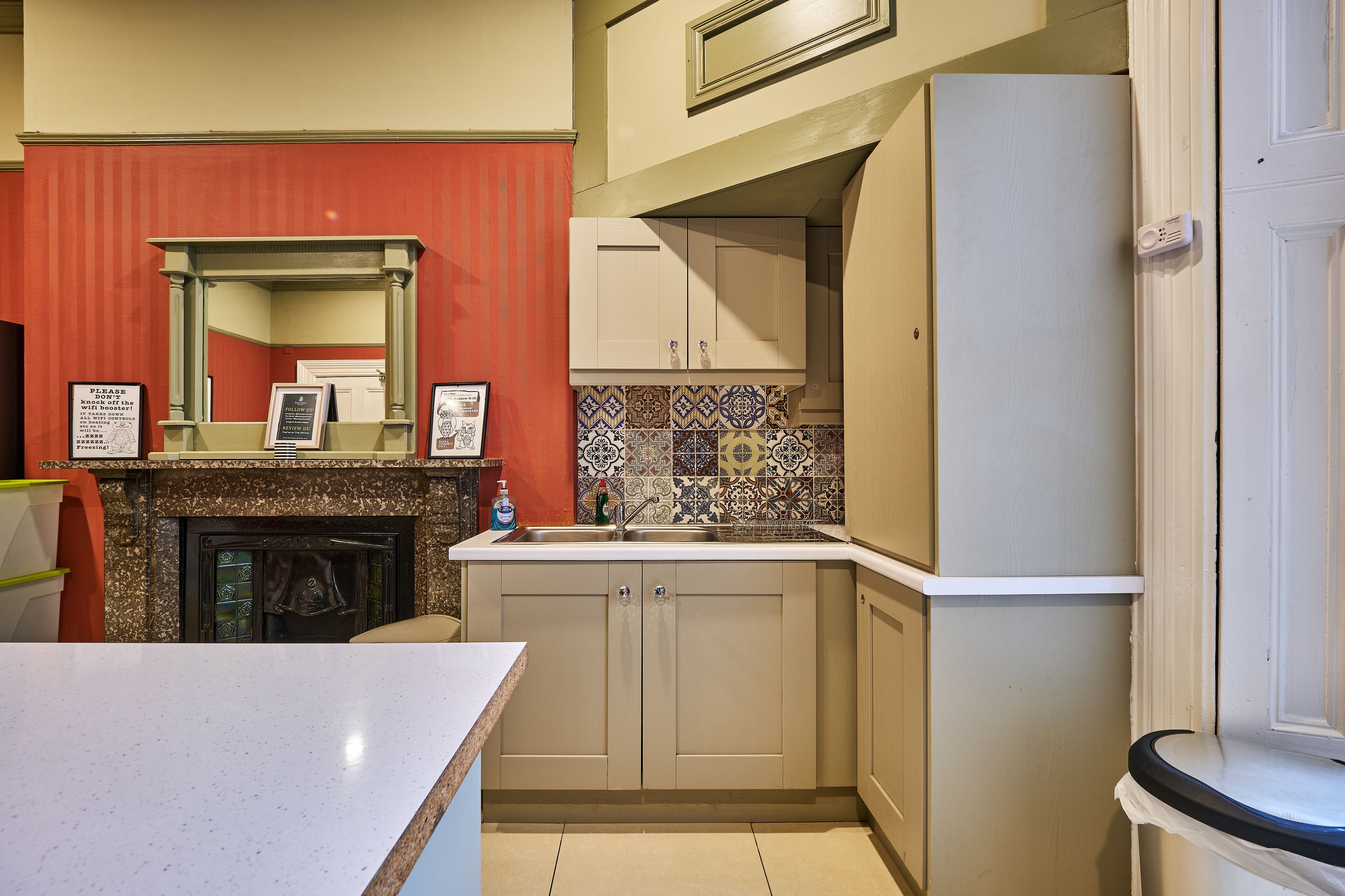 A compact kitchen with a built-in oven, a sink, and a tiled backsplash.