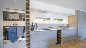 Eine moderne Küche mit eingebauten Geräten, einem Weinkühler und einem Fenster mit Blick.