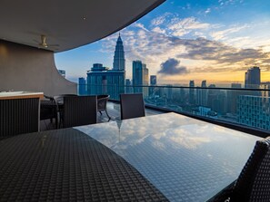 Eine Dachterrasse mit weiter Aussicht auf die Stadt, darunter ein markantes Wolkenkratzer.