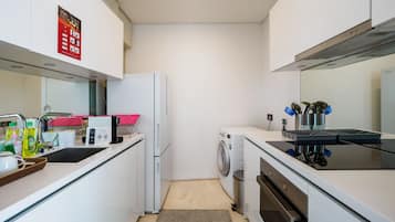 Frigorífico grande, horno, placa de cocina y utensilios de cocina