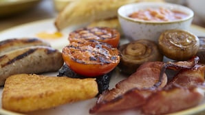 A plate of breakfast food including eggs, bacon, mushrooms, and grilled tomatoes. - The Grainary Boutique Hotel (Scarborough)