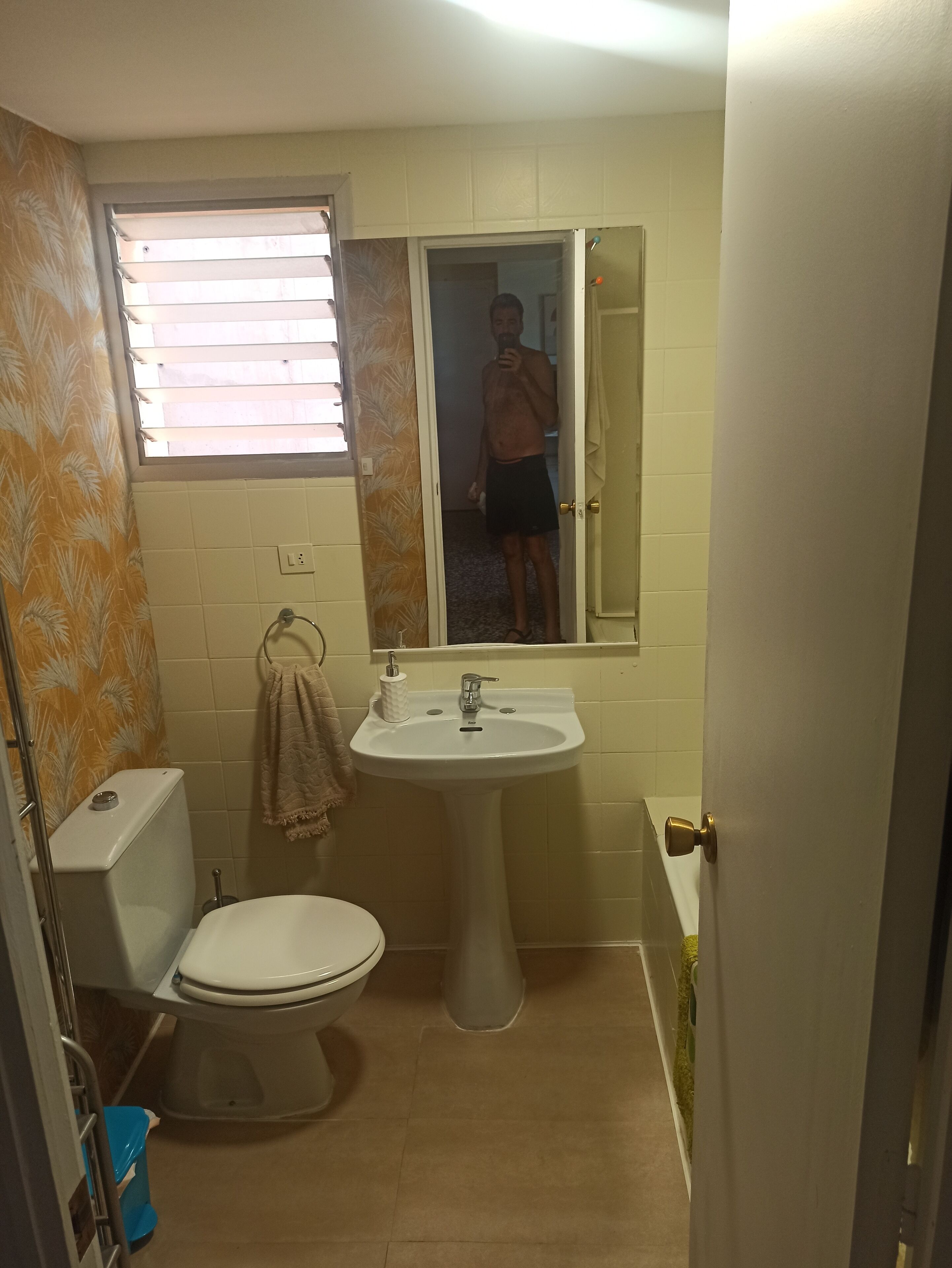 Une salle de bain avec des toilettes, un lavabo et une fenêtre.
