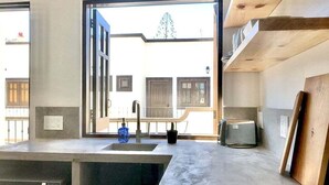 A kitchen with a large window, a sink, a toaster, and a potted plant. - Loreto80– Studio Palo Blanco (Loreto)