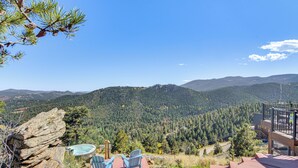 A mountain view with a hot tub, chairs, and a rock formation. - The View at Mountain Retreat By Red Rocks & Golden (Evergreen)