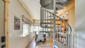 A spiral staircase leading to a dining area with a view of the kitchen. - The View at Mountain Retreat By Red Rocks & Golden (Evergreen)