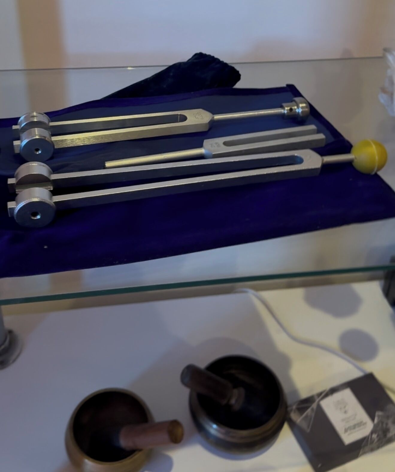 Una exhibición de herramientas mecánicas sobre una estantería de vidrio.