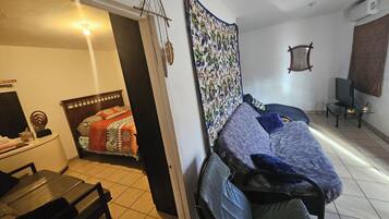 Een kamer met een bed, een stoel, een bureau en een televisie.