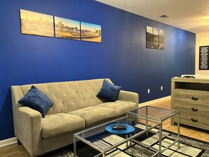 Living room with blow up mattress and linens for 5th guest inside the cabinet 