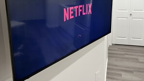 A flat-screen TV mounted on a white wall with a closed white door in the background. - Cozy Private 1-bedroom Basement Suite with free parking (Winnipeg)
