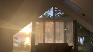 Une chambre avec une grande fenêtre, un lit et un canapé.