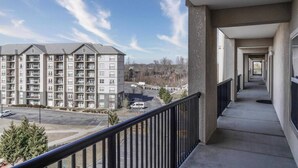 Un immeuble résidentiel à plusieurs étages, doté de balcons, d’un parking et surplombant un ciel dégagé.