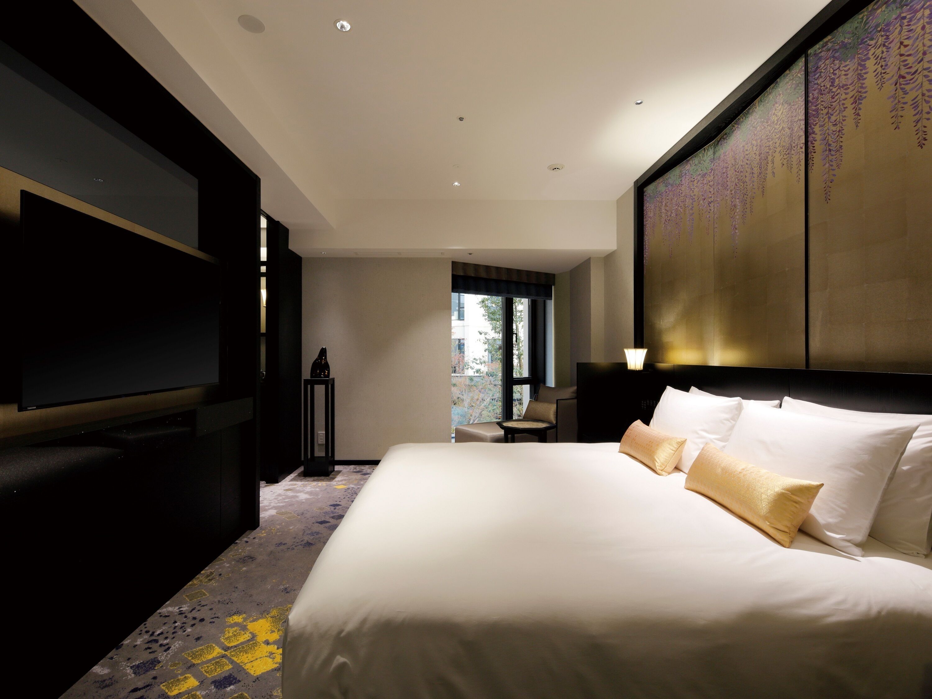 Une chambre d’hôtel dotée d’un grand lit, d’un téléviseur à écran plat et offrant une vue sur l’extérieur.