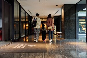 Un moderno vestíbulo de hotel con piso pulido, una recepción y una pared de vidrio.