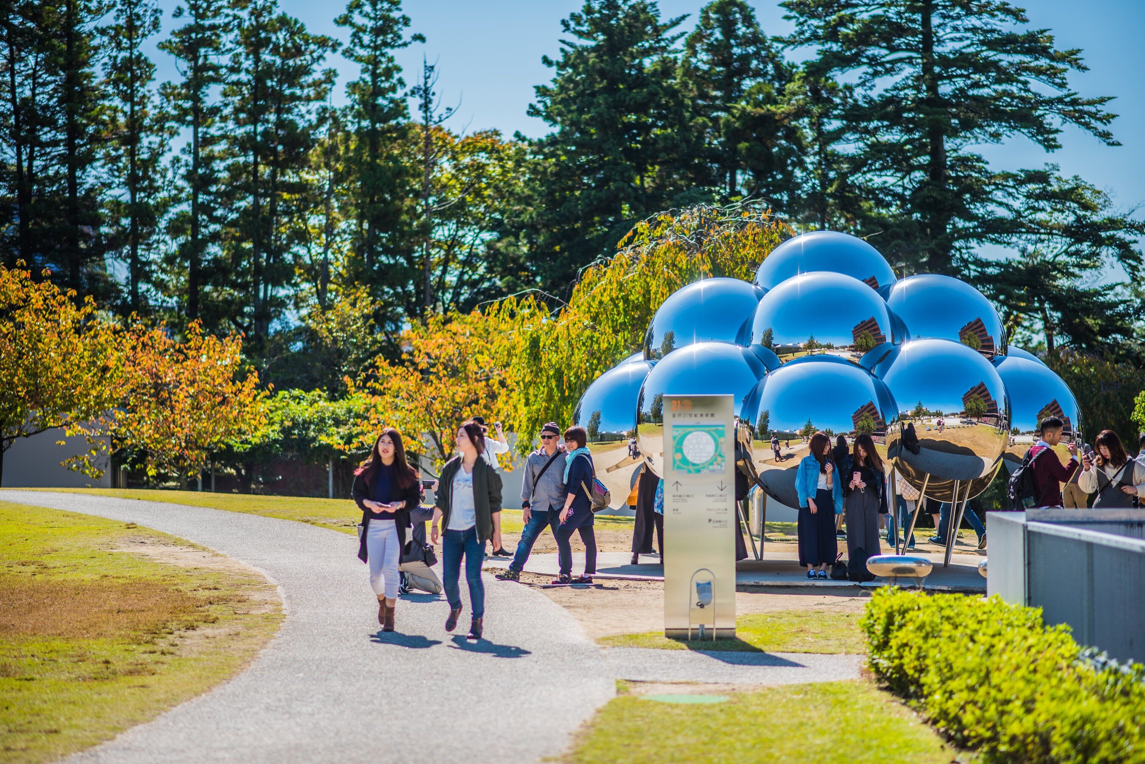A pathway leading to a modern sculpture installation with spherical structures.